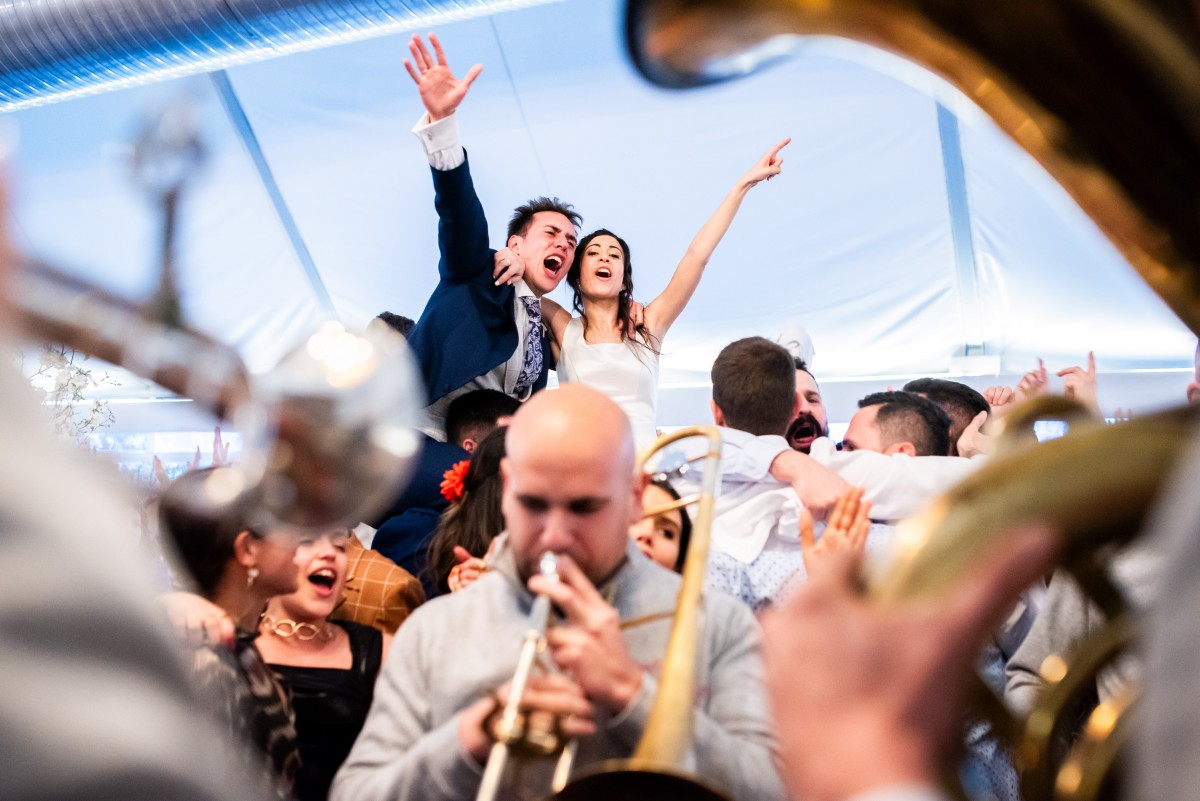 Inés y Álvaro celebrando con la banda de música de la boda